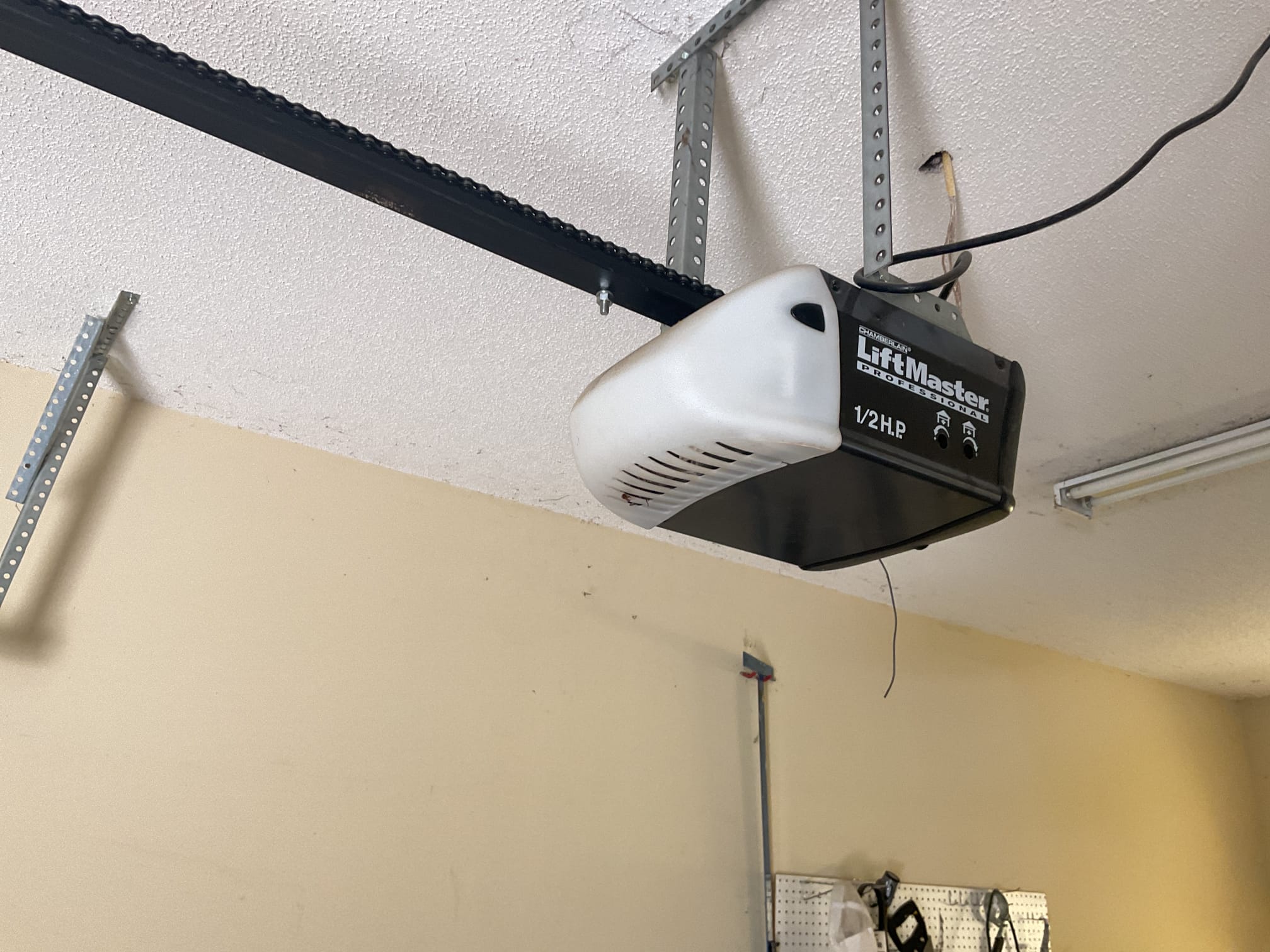 New LiftMaster garage door opener mounted to a garage ceiling with its chain rail attached