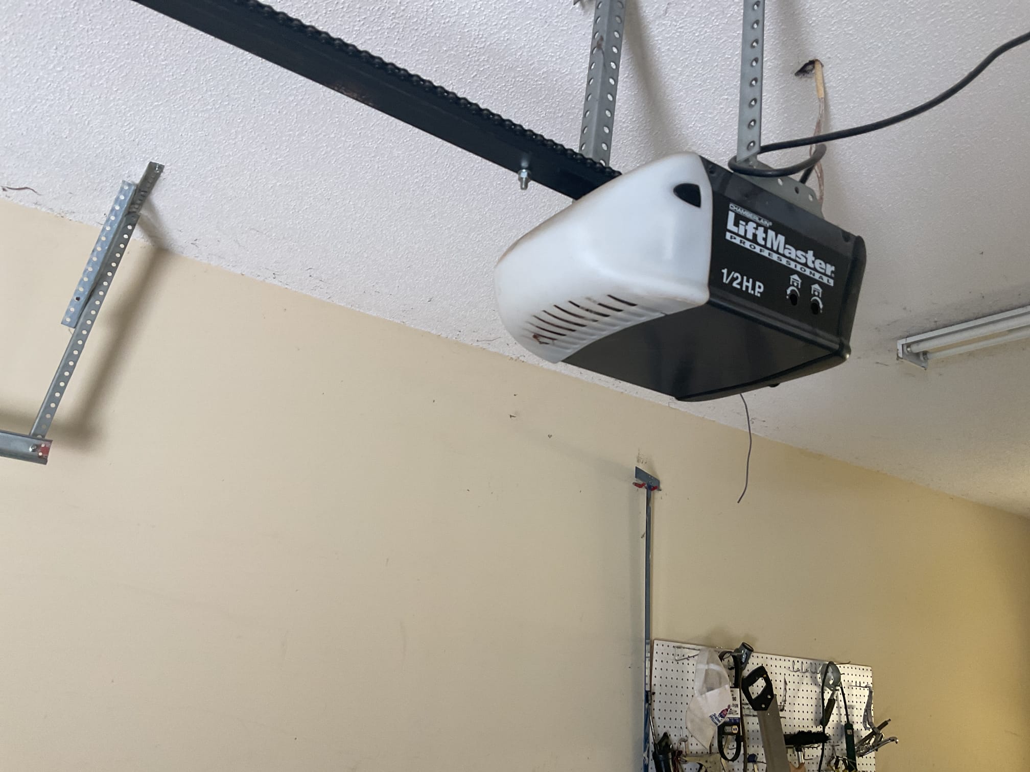 New LiftMaster garage door opener and chain rail installed above a garage door